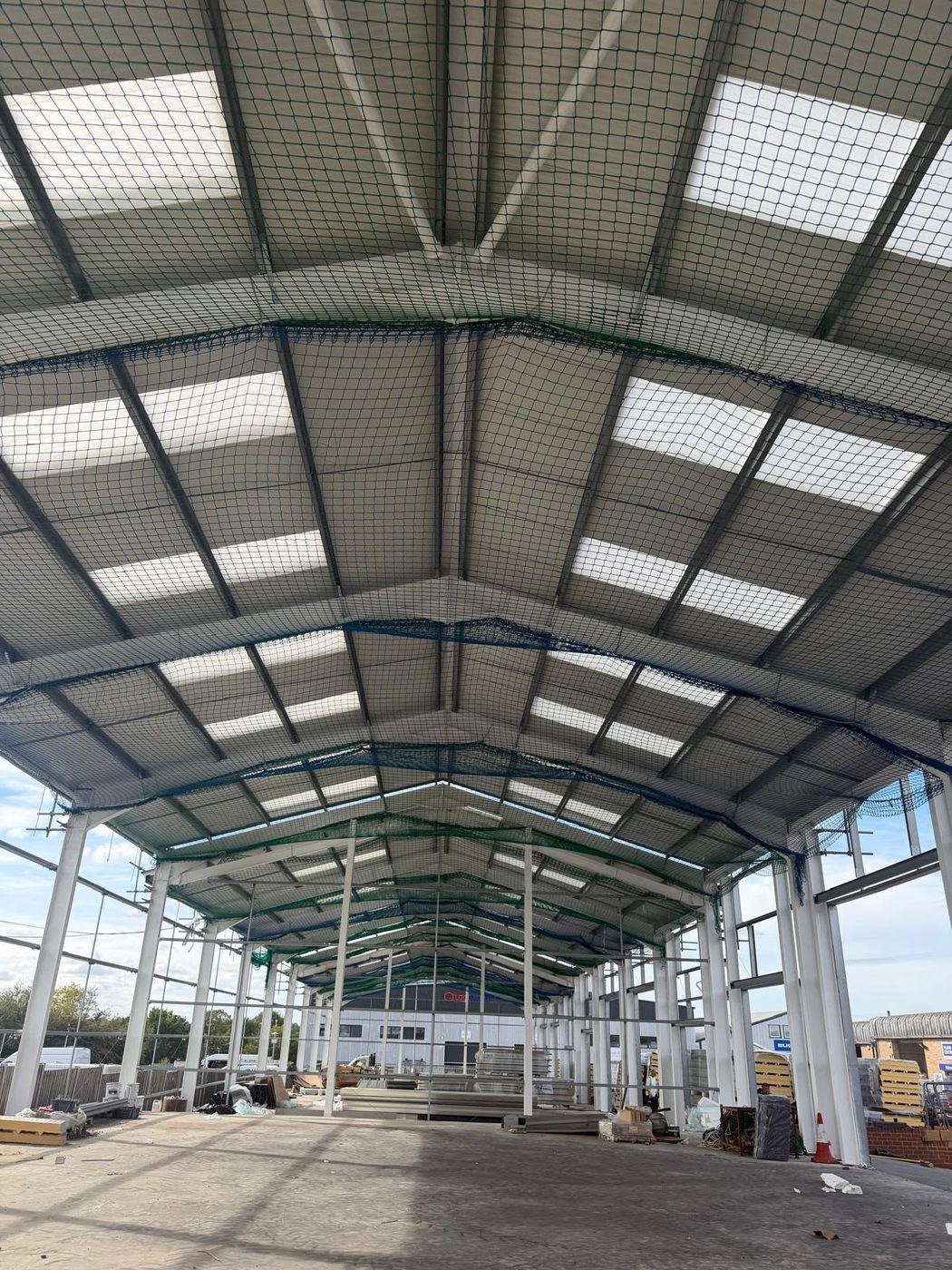 Inside the Springwood Court steel frame, with roof sheets, rooflights and safety netting fitted