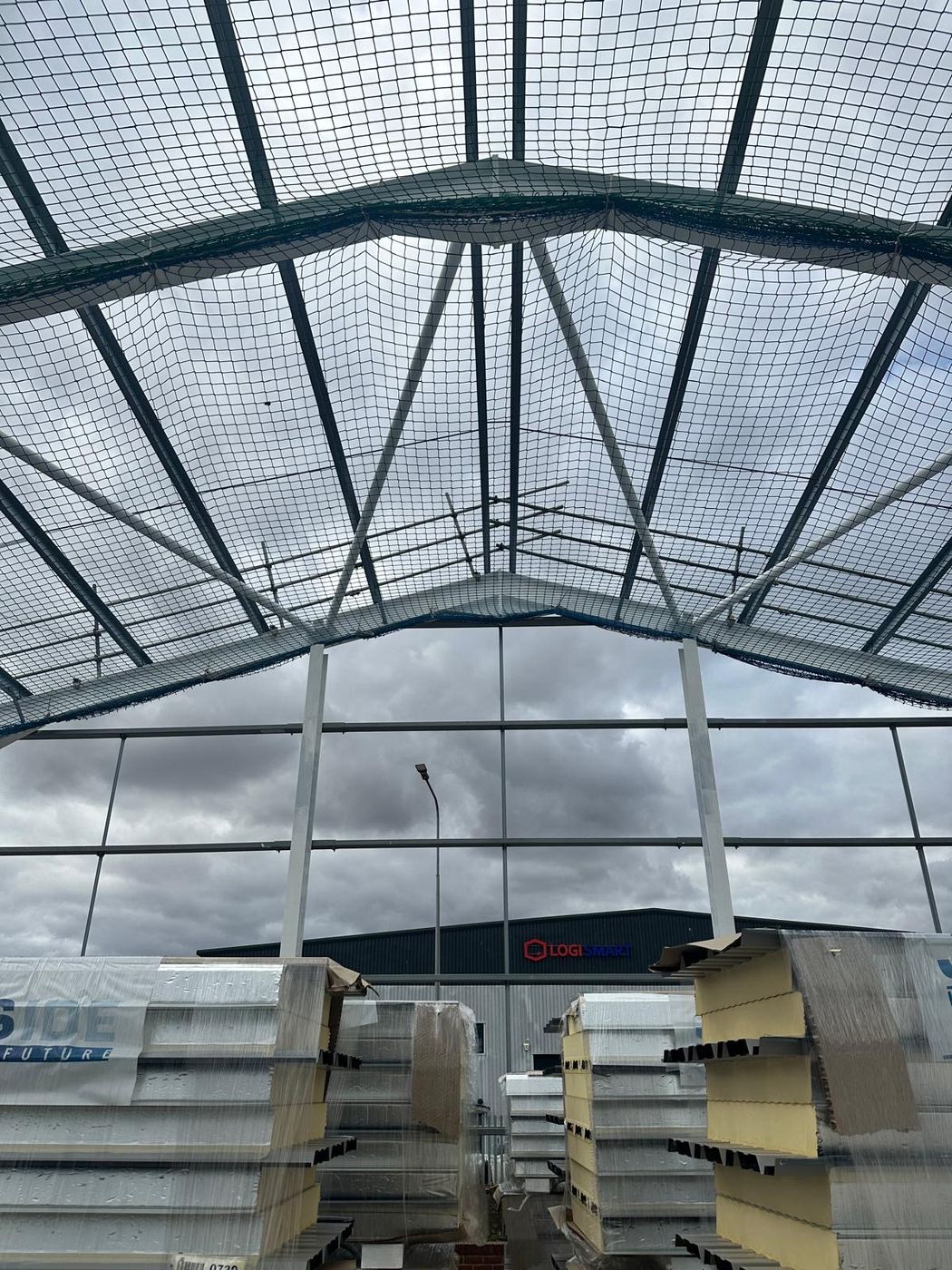 Steel portal frame with roof safety netting at Springwood Court