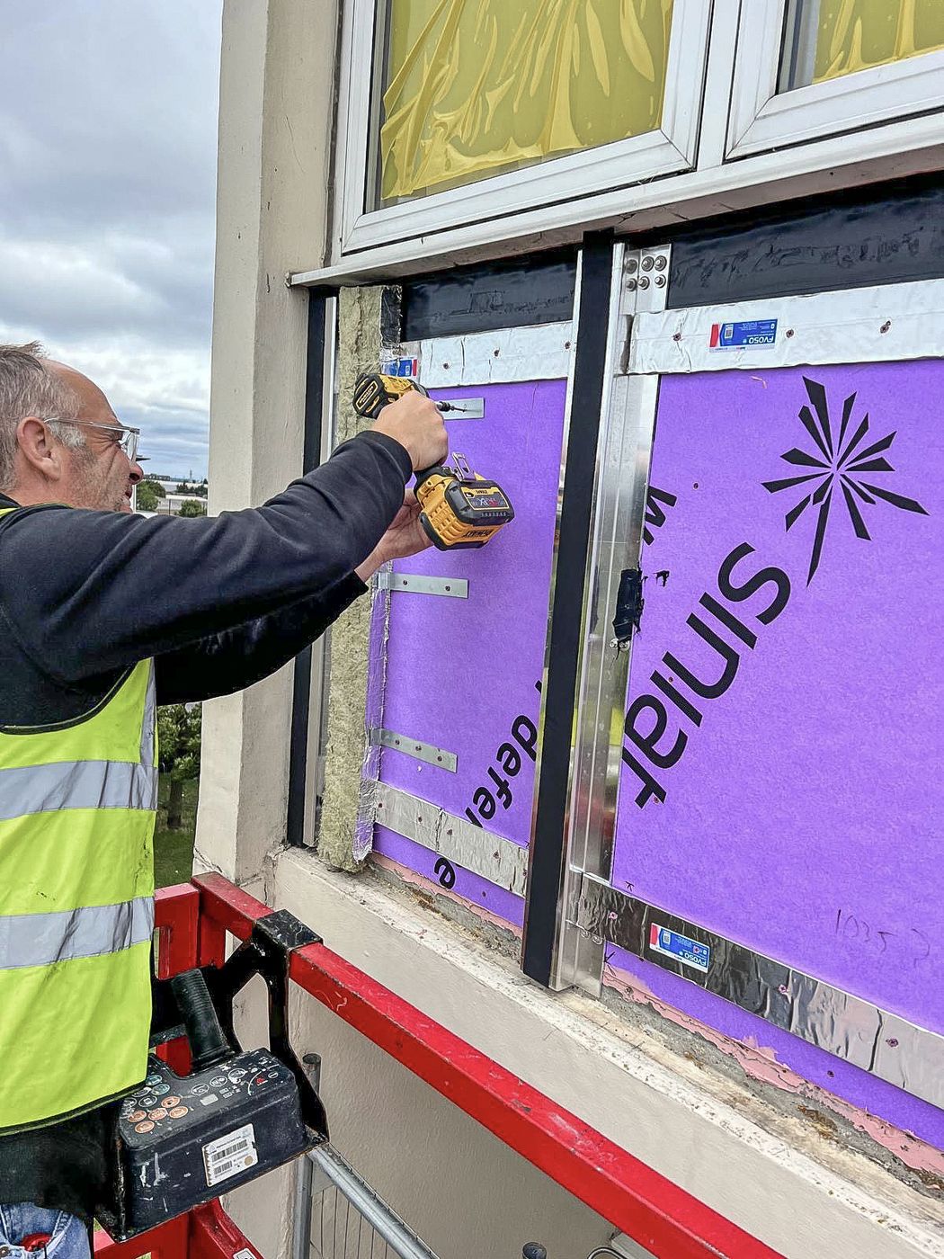 UDM operative installing insulation board to an existing building