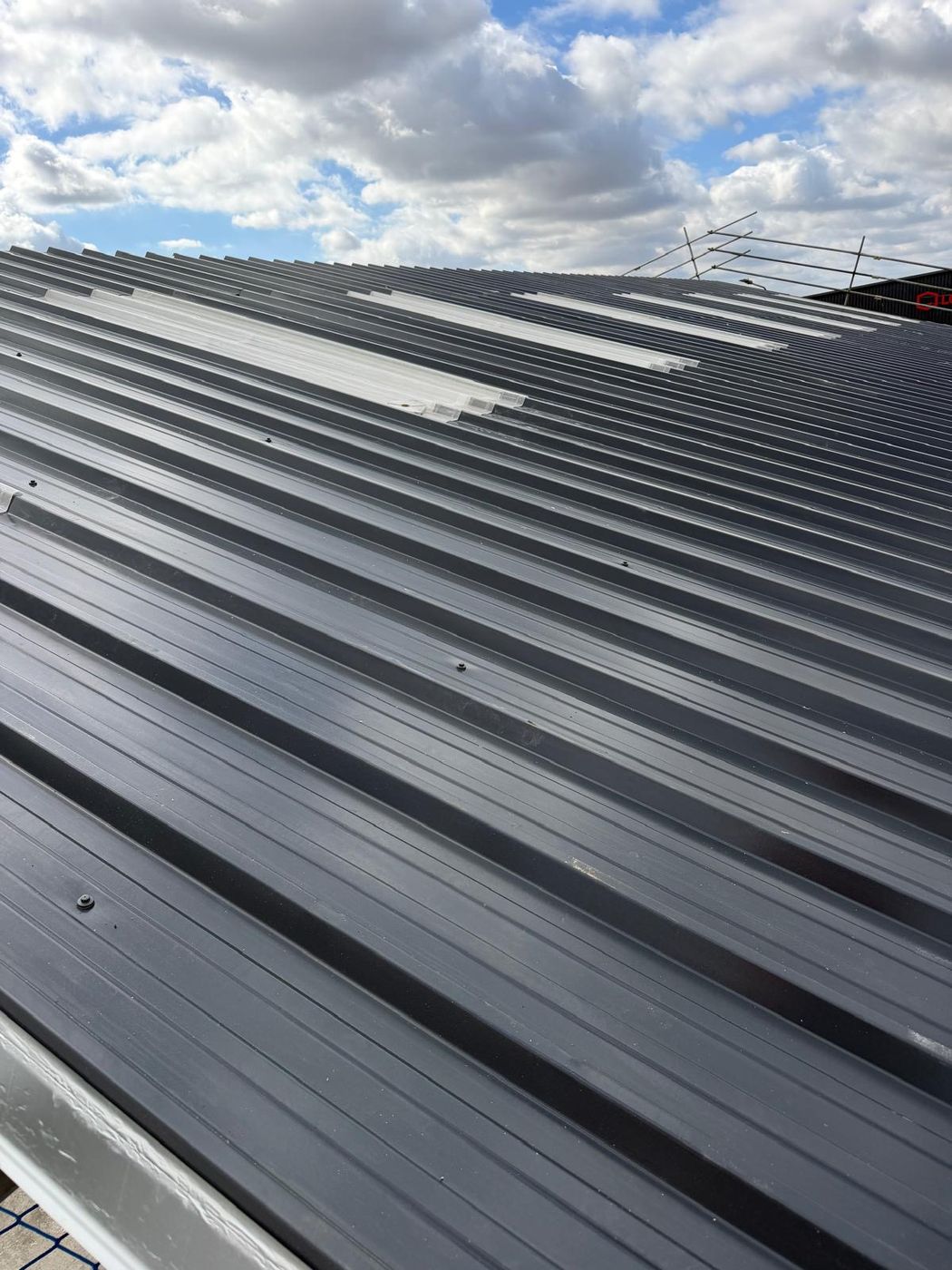 Completed industrial roof with new grey sheets and rooflight strips