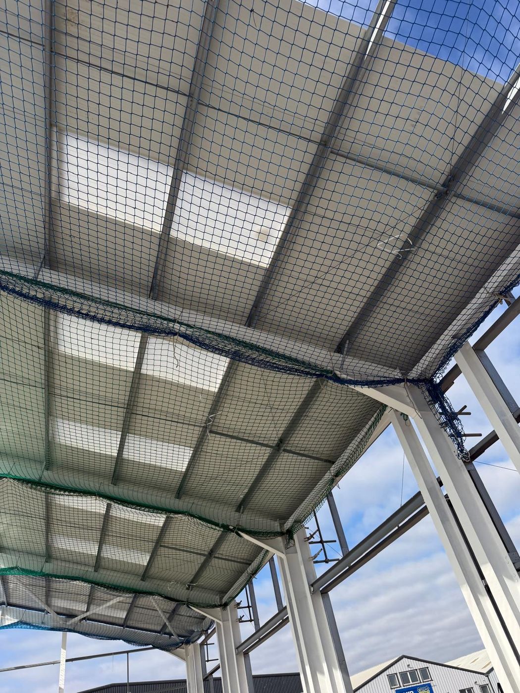 Interior liner panels installed under an industrial roof with safety netting