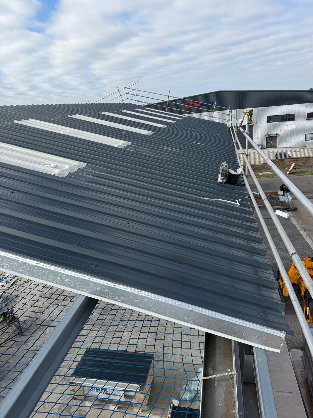Industrial roof refurbishment with new sheets, rooflights and scaffold